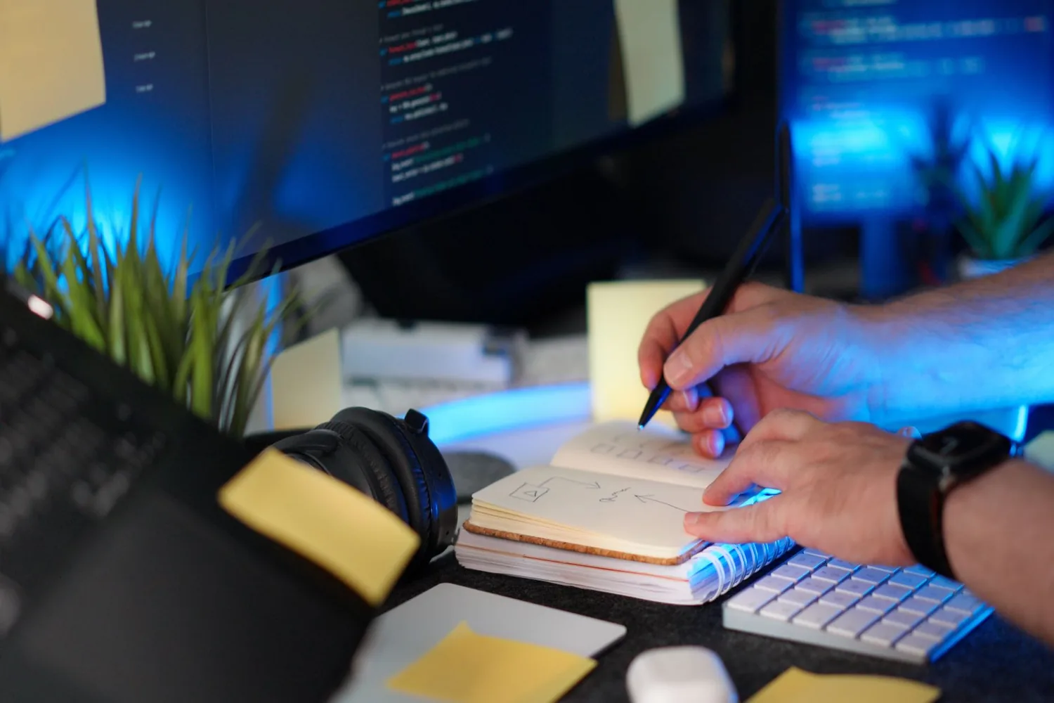 Notebook com código fonte na tela ao lado de documentos impressos