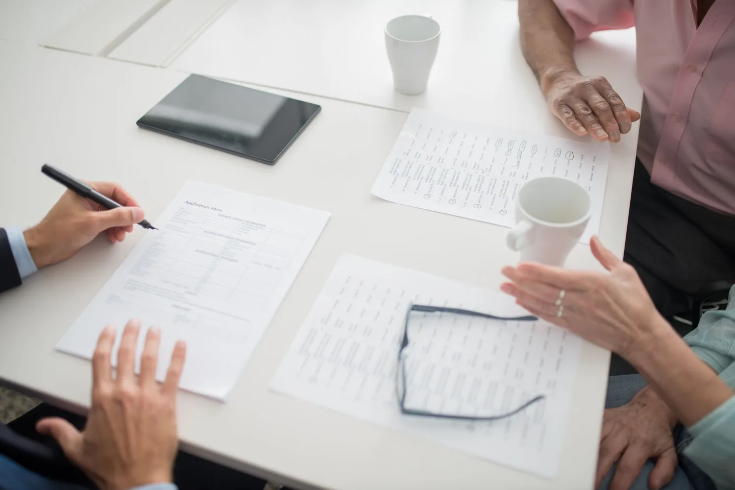 Reunião de negócios com documentos, calculadora e anotações sobre a mesa