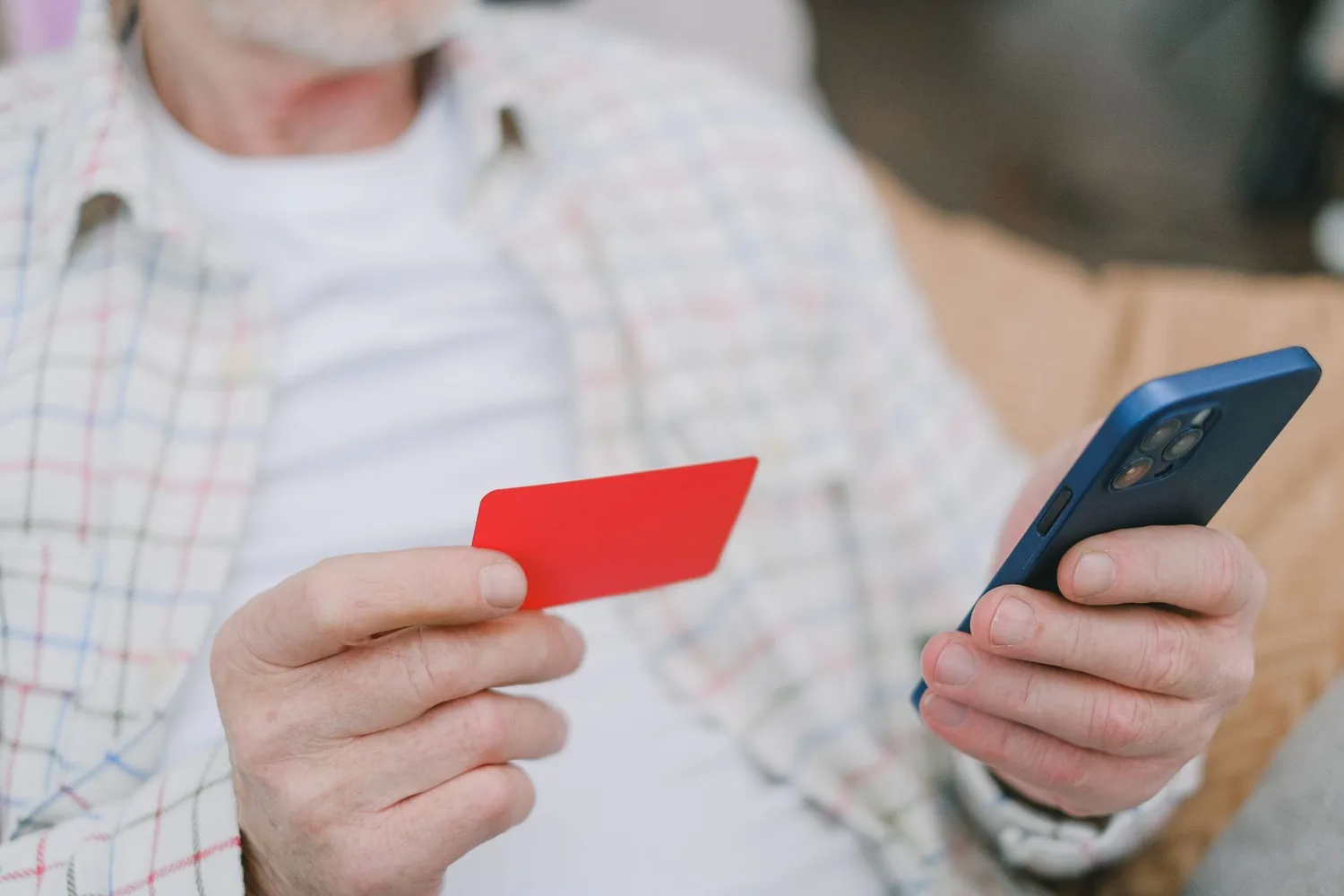 Mão segurando um celular com tela de pagamento por aproximação em uma loja