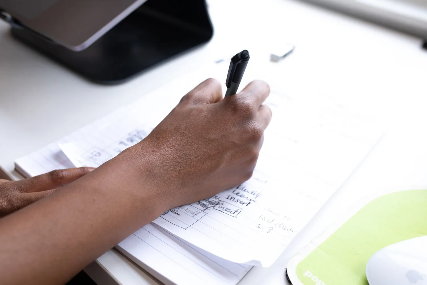 Prancheta com contrato e caneta sobre mesa de escritório com notebook ao fundo