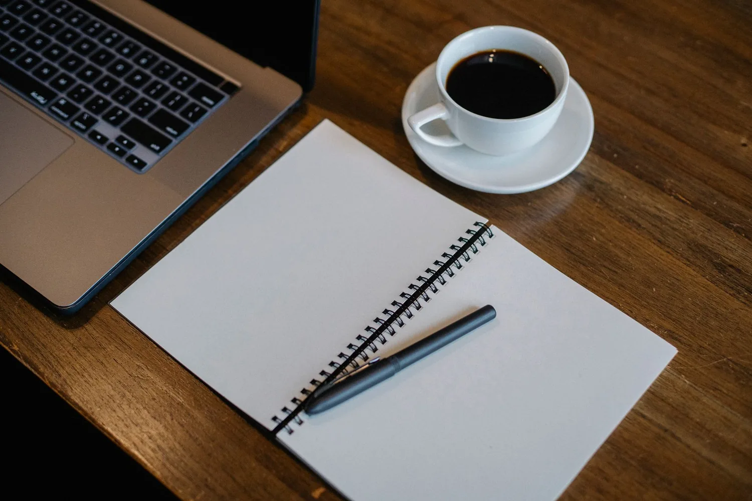 Equipe de trabalho reunida em volta de notebooks em espaço de coworking