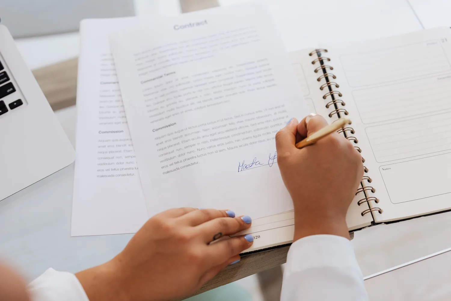 Documento de normas internas impresso ao lado de um computador em uma mesa de escritório