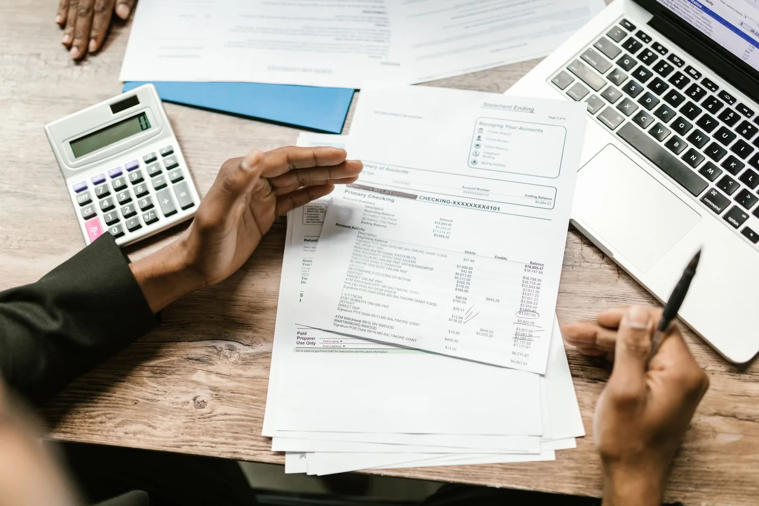 Contrato impresso ao lado de calculadora e caneta sobre uma mesa de revisão