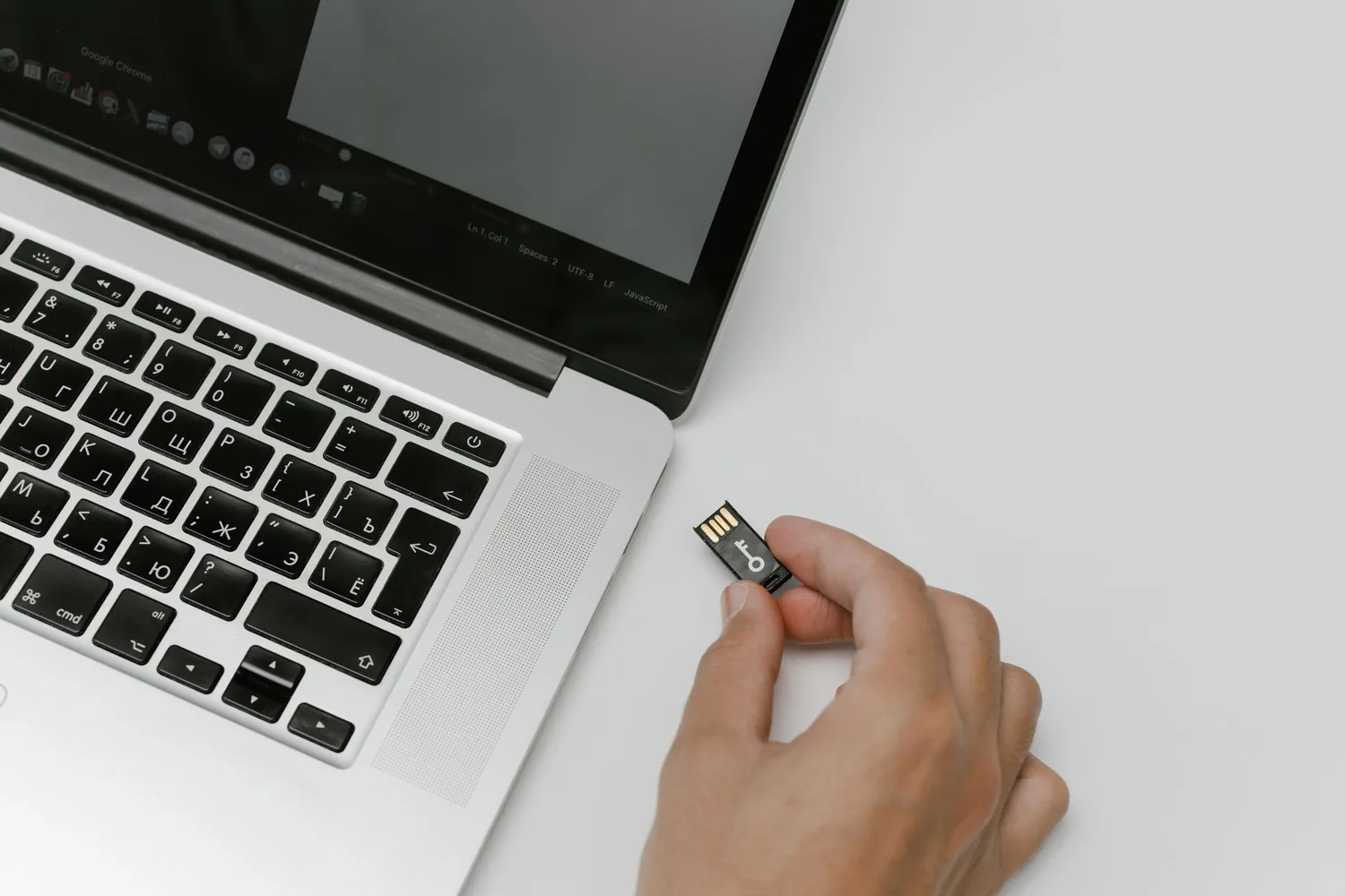 Notebook com pasta de arquivos abertos e unidade externa conectada sobre a mesa